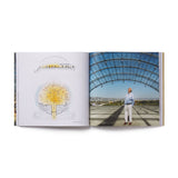 Open book showing a diagram on one page and a person standing in front of a large glass roof on the other the dome of the academy museum in los angeles, california.