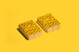 Two wooden plates with black pattern on a yellow background
