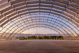 Large indoor sports arena with a glass roof at sunset. Capture the magic of the Dolby Family Terrace with our exclusive postcard! Enjoy panoramic views of Hollywood and beyond from this stunning venue.