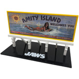 Model of a billboard with 'Amity Island Welcomes You' text and 'Jaws' branding on a black base.