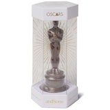 Oscar statuette in a box with 'andSons' branding on a white background. Indulge in the Oscars® x AndSons chocolate statuette, a luxurious treat for film lovers! Handcrafted with ethically sourced cacao and dusted with gold.
