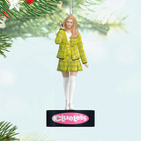 Christmas ornament of a character in a yellow plaid outfit with 'Clueless' branding, hanging from a tree.