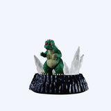 Green dinosaur figurine on a black base with ice crystals against a white background. New arrival Godzilla blind box figures Academy Museum