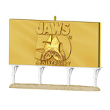 Gold 'Jaws 50th Anniversary' billboard ornament on a white background