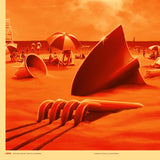 Surreal beach scene with geometric sculptures and umbrellas under a red sky.