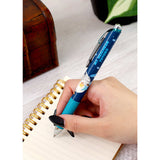 Hand holding a blue pen with a character design on a notebook. Studio Ghibli My Neighbor Totoro Ballpoint Pen (Totoro’s Umbrella) 