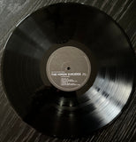 Vinyl record with 'The Virgin Suicides' album on a wooden surface