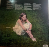 Vinyl record cover with a person sitting in grass, featuring text and branding. Dive into the melancholic world of The Virgin Suicides with its Original Soundtrack on vinyl. Featuring classics from 10cc, Boston, and more, it's a collector's gem.