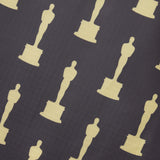 Closeup of the ripstop black nylon fabric with gold all over oscar statuette print design