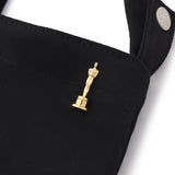 close up view of the gold oscar lapel pin on a black tote bag