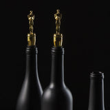 Gold Oscar Statuette wine stopper shown in a black wine bottle