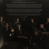 Group of people sitting together in a dark setting with text overlay