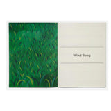 Notebook with green abstract design on one page and 'Wind Song' text on the other, on a white background.
