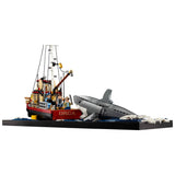 LEGO model of a fishing boat named 'Orca' with a shark nearby on a white background Jaws (1975) 50th Anniversary Lego Set