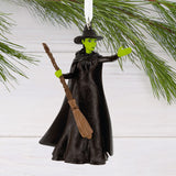Elphaba from Wicked Witch ornament with a broom hanging on a Christmas tree branch