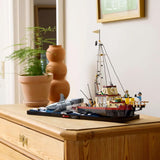 Model ship on a wooden surface with a plant and decorative items in the background Jaws (1975) 50th Anniversary Lego Set