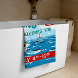 Festive towel with sailboat design and text on a bathtub